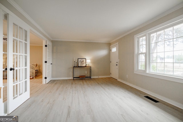 spare room with crown molding, light hardwood / wood-style floors, and french doors