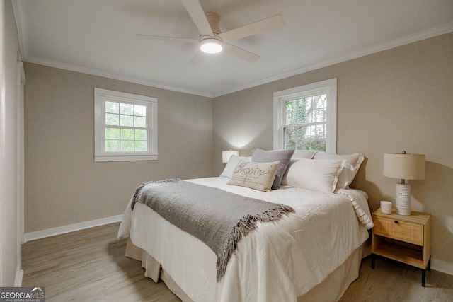 bedroom with ceiling fan, ornamental molding, and light hardwood / wood-style flooring