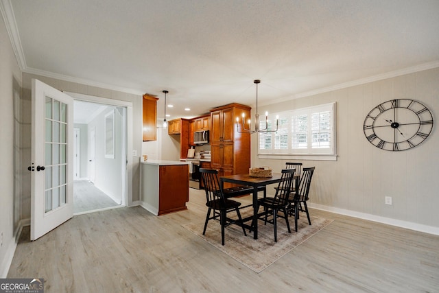 dining room featuring crown molding, a notable chandelier, and light wood-type flooring