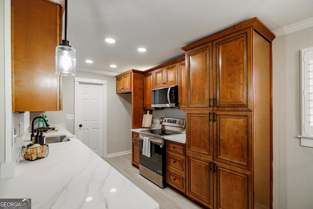 kitchen featuring stainless steel appliances, pendant lighting, light stone countertops, crown molding, and sink