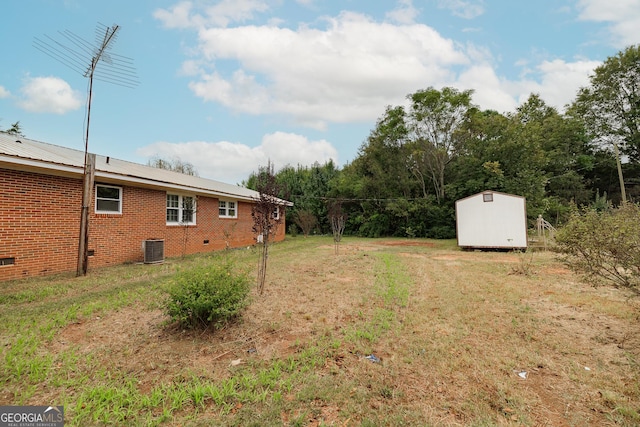 view of yard featuring a storage shed and central air condition unit