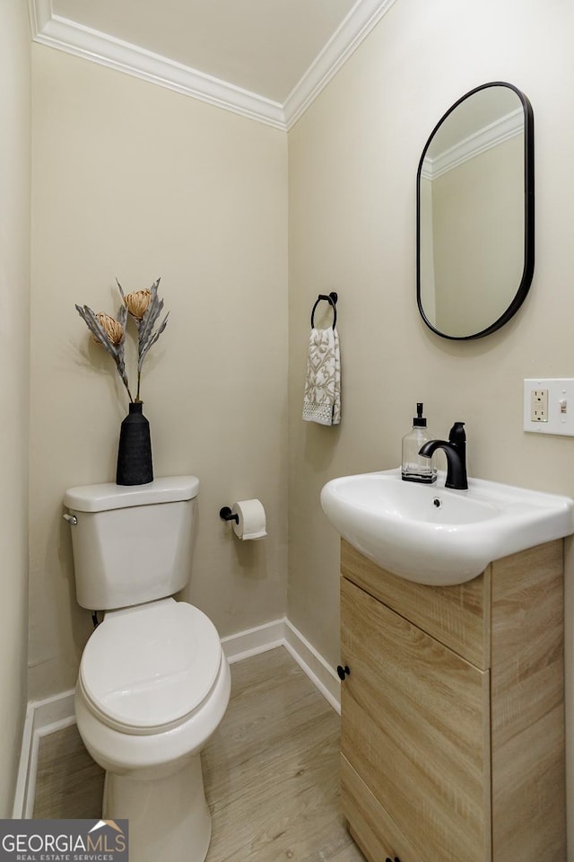 bathroom with hardwood / wood-style floors, toilet, vanity, and ornamental molding