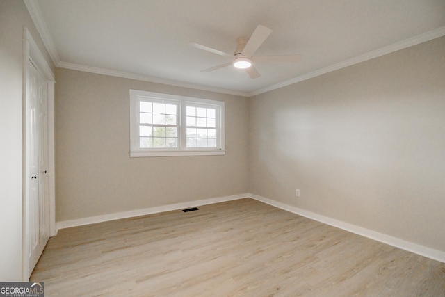 empty room featuring ceiling fan, light hardwood / wood-style flooring, and crown molding