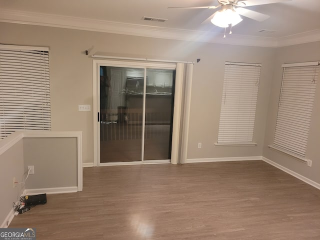 empty room with ceiling fan, hardwood / wood-style floors, and ornamental molding