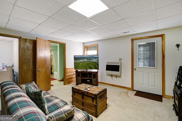 living room with a paneled ceiling, heating unit, and light carpet