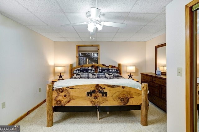 carpeted bedroom featuring ceiling fan and a drop ceiling