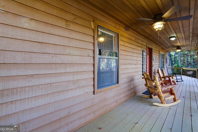 wooden deck featuring covered porch and ceiling fan