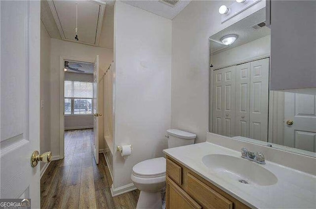 bathroom with hardwood / wood-style floors, vanity, and toilet