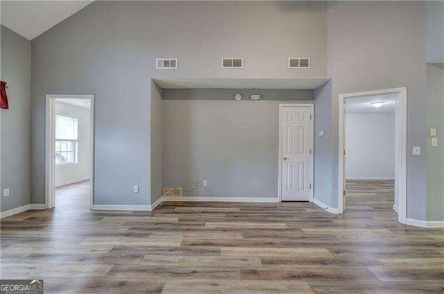 empty room featuring light hardwood / wood-style floors and high vaulted ceiling