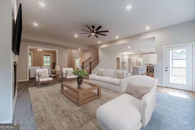 living room with light hardwood / wood-style floors, a healthy amount of sunlight, and ceiling fan