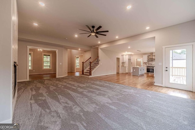 unfurnished living room featuring ceiling fan and light hardwood / wood-style flooring