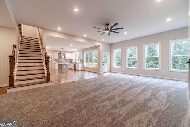 unfurnished living room with ceiling fan and light colored carpet