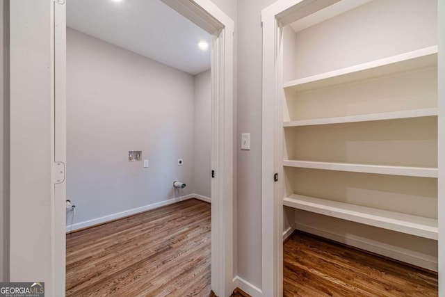 clothes washing area with hookup for an electric dryer, washer hookup, and hardwood / wood-style flooring