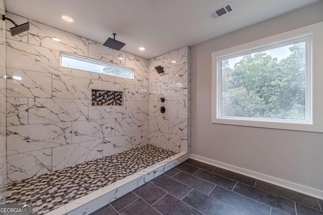 bathroom with a wealth of natural light, tile patterned floors, and tiled shower