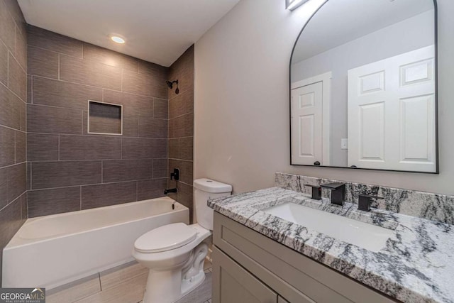 full bathroom featuring toilet, vanity, and tiled shower / bath