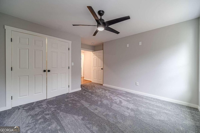 unfurnished bedroom featuring ceiling fan, a closet, and dark carpet