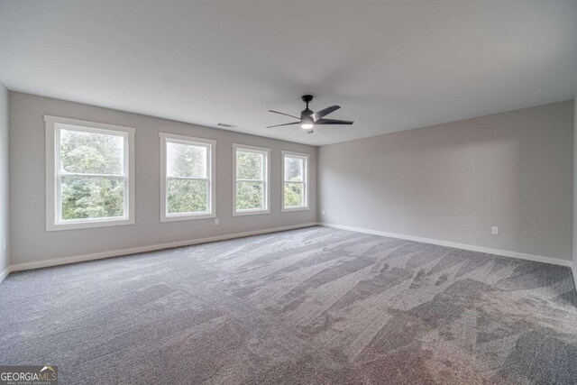 unfurnished room featuring carpet, plenty of natural light, and ceiling fan