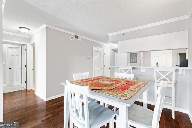 dining space featuring dark wood-type flooring, a textured ceiling, and crown molding