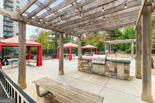 view of patio with an outdoor kitchen, area for grilling, a pergola, and a gazebo