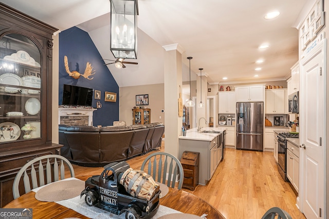 interior space with ceiling fan, crown molding, light hardwood / wood-style flooring, and lofted ceiling