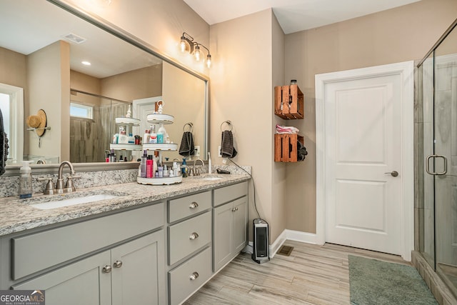 bathroom with walk in shower, wood-type flooring, and vanity