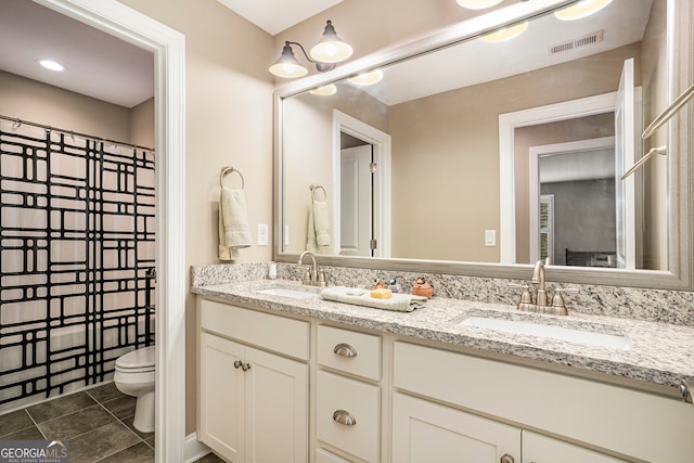 bathroom featuring tile patterned flooring, vanity, and toilet