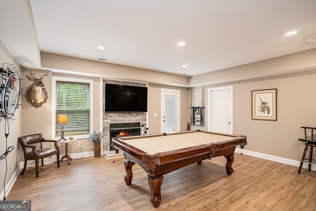 playroom featuring pool table, a fireplace, and light hardwood / wood-style flooring