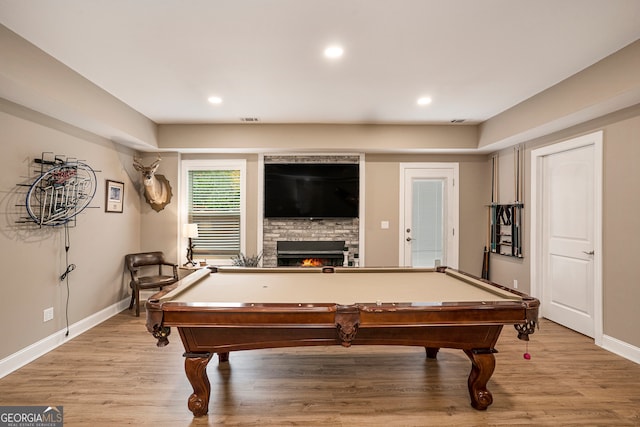 game room featuring pool table, a fireplace, and light hardwood / wood-style floors