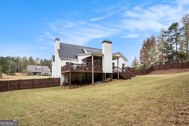 rear view of property featuring a lawn and a deck