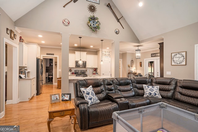 living room featuring high vaulted ceiling, light hardwood / wood-style floors, and crown molding