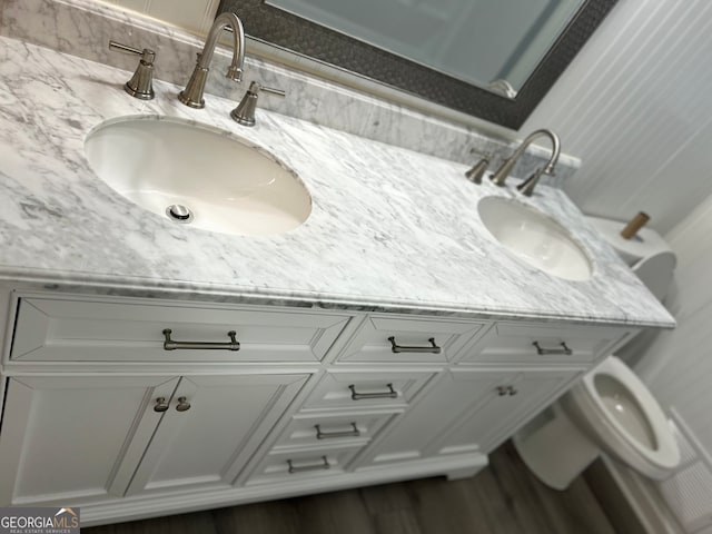 bathroom featuring wood-type flooring, vanity, and toilet