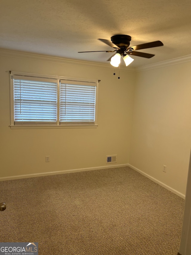 spare room with crown molding, ceiling fan, and carpet floors