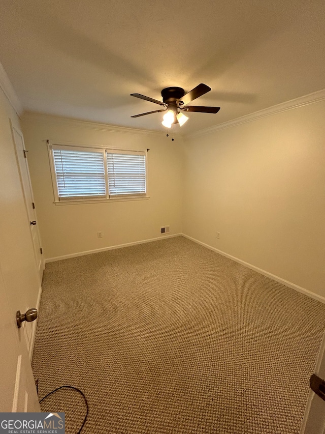 unfurnished room featuring ceiling fan, ornamental molding, and carpet