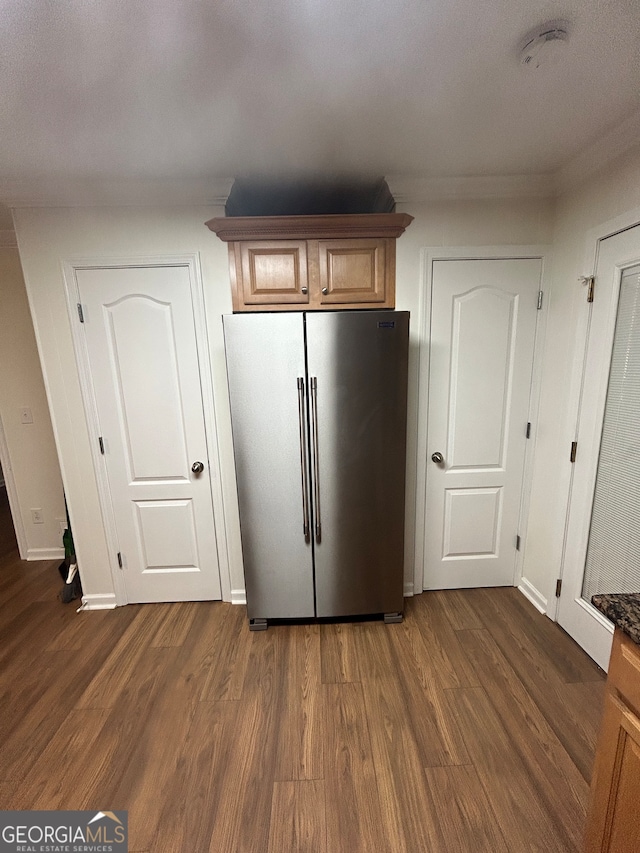 kitchen with dark wood-type flooring and stainless steel refrigerator