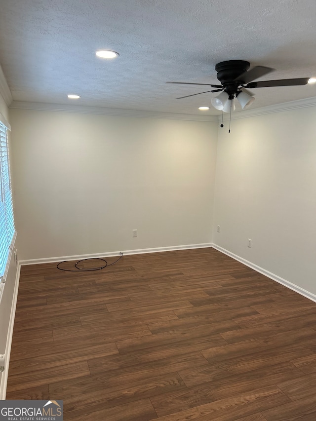 spare room featuring dark hardwood / wood-style floors, plenty of natural light, a textured ceiling, and ornamental molding