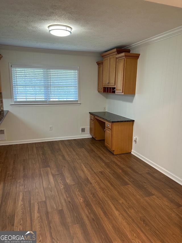 kitchen featuring built in desk, a healthy amount of sunlight, dark hardwood / wood-style flooring, and ornamental molding