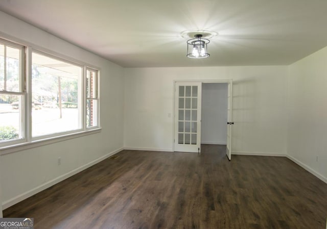 spare room with dark wood-type flooring and french doors