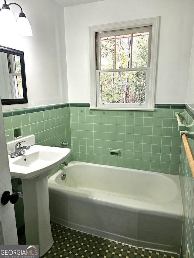 bathroom featuring a washtub and tile walls