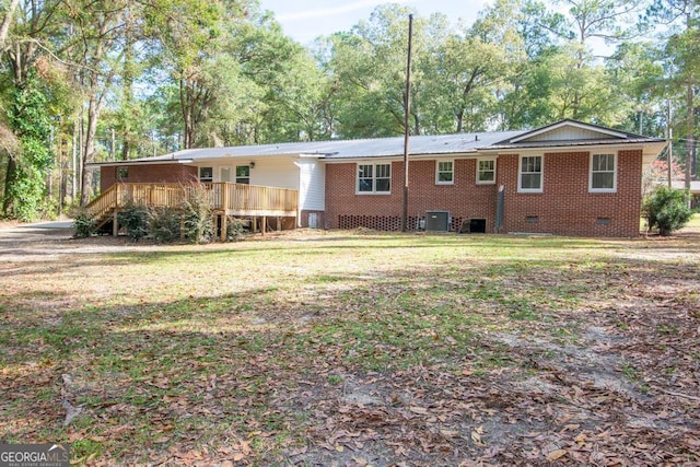 rear view of property featuring a yard, central AC, and a deck