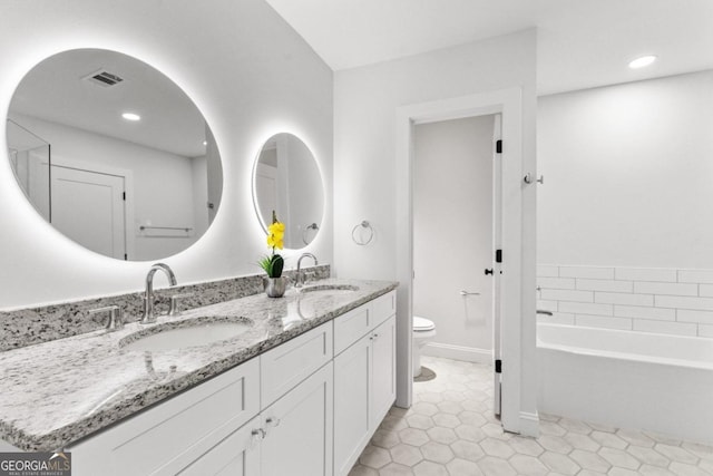 bathroom featuring a bathing tub, tile patterned flooring, vanity, and toilet