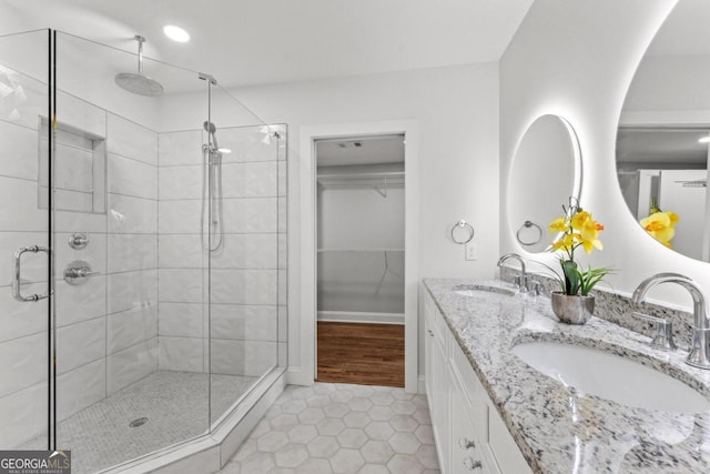 bathroom with vanity, a shower with shower door, and tile patterned flooring