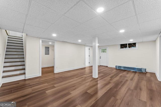 basement with a drop ceiling and dark hardwood / wood-style floors