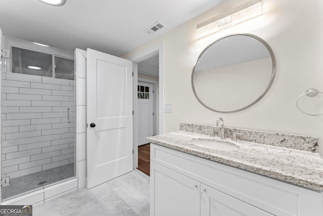 bathroom with a shower with door and vanity