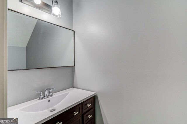 bathroom featuring vanity and lofted ceiling