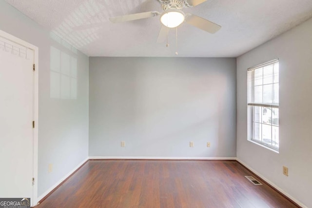 spare room featuring a textured ceiling, dark hardwood / wood-style flooring, and ceiling fan