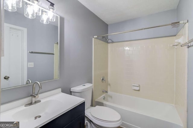 full bathroom with toilet, tiled shower / bath combo, vanity, and a textured ceiling