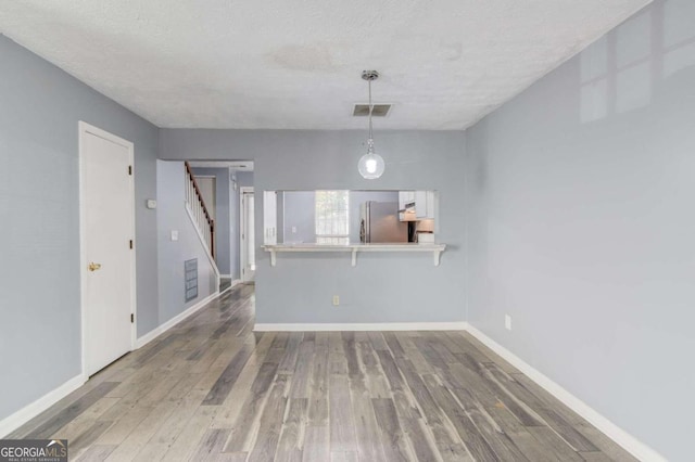 unfurnished dining area featuring hardwood / wood-style floors and a textured ceiling