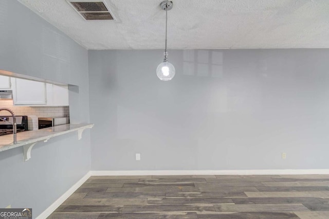 kitchen featuring white cabinetry, pendant lighting, a textured ceiling, and dark hardwood / wood-style floors