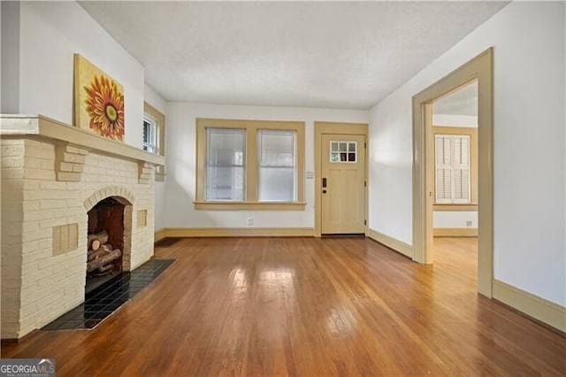 unfurnished living room featuring a fireplace and wood-type flooring