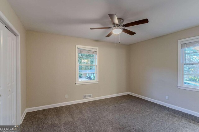 carpeted spare room featuring ceiling fan